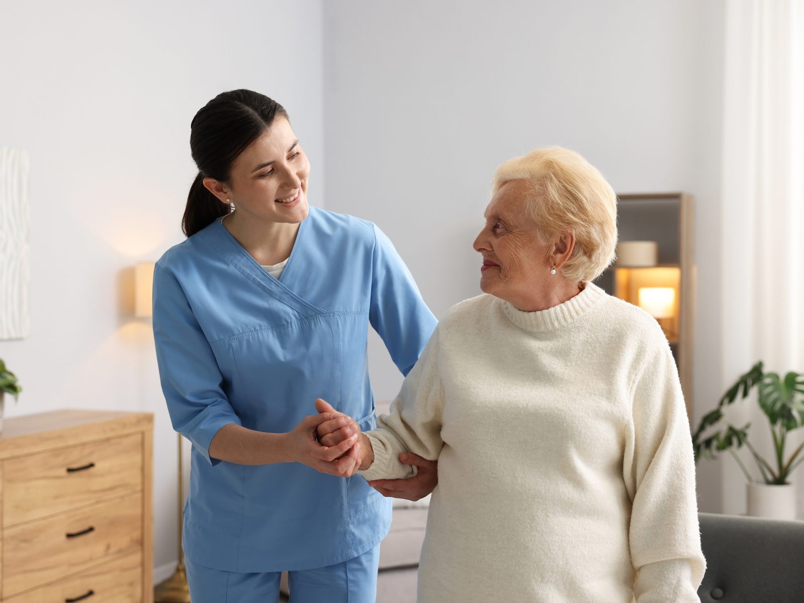 A physiotherapist guiding an older man through balance exercises at home