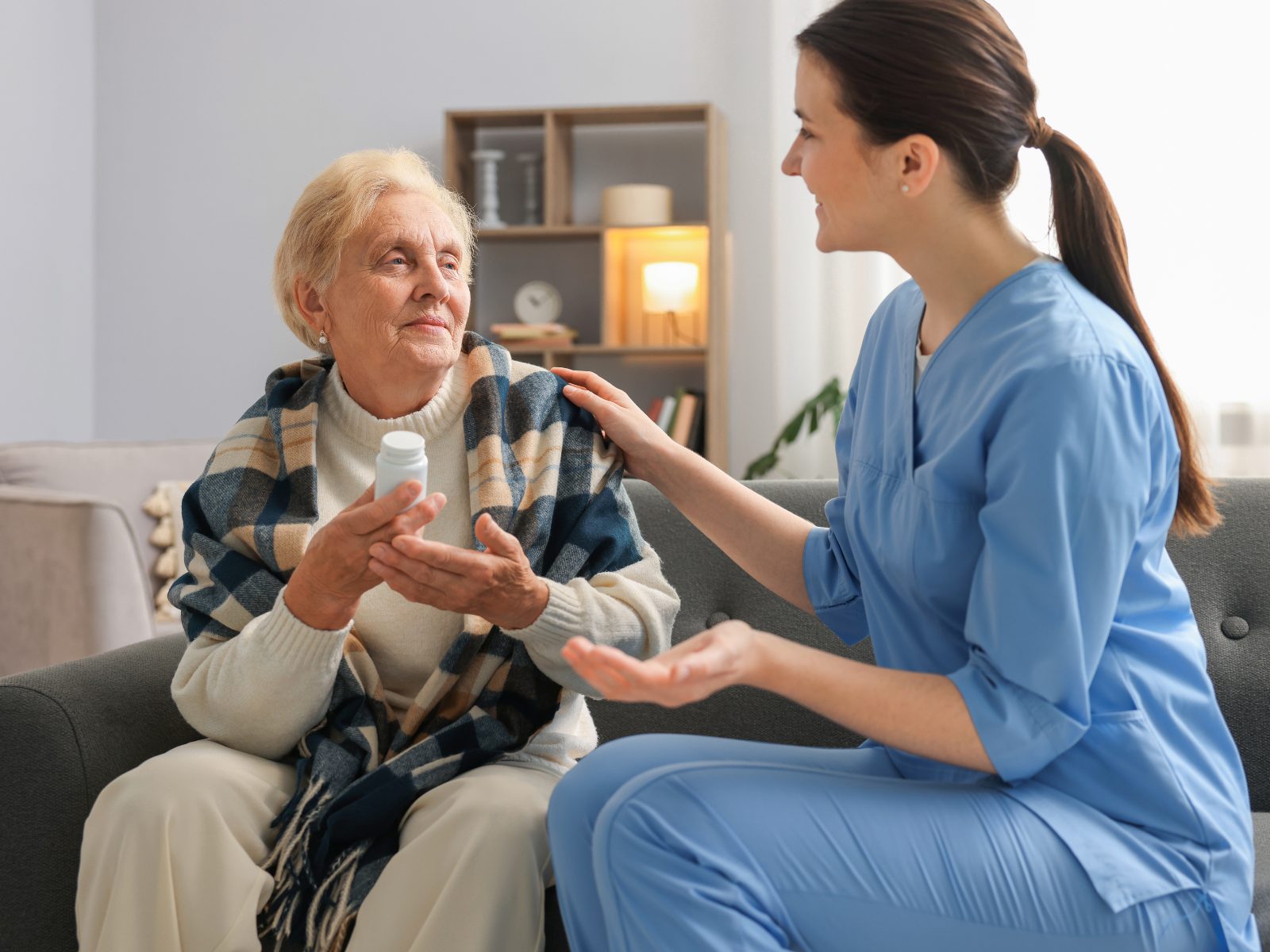 A registered nurse checking a client's blood pressure at home